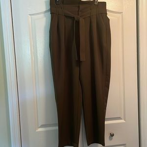 Women’s army green pants with cinched waist and accent belt.